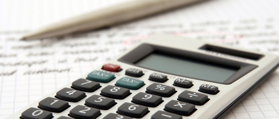 Le pacte Dutreuil permet une exonération de 75 % de la valeur des droits lors d'une transmission. Calculatrice posée sur un cahier à côté d'un stylo.