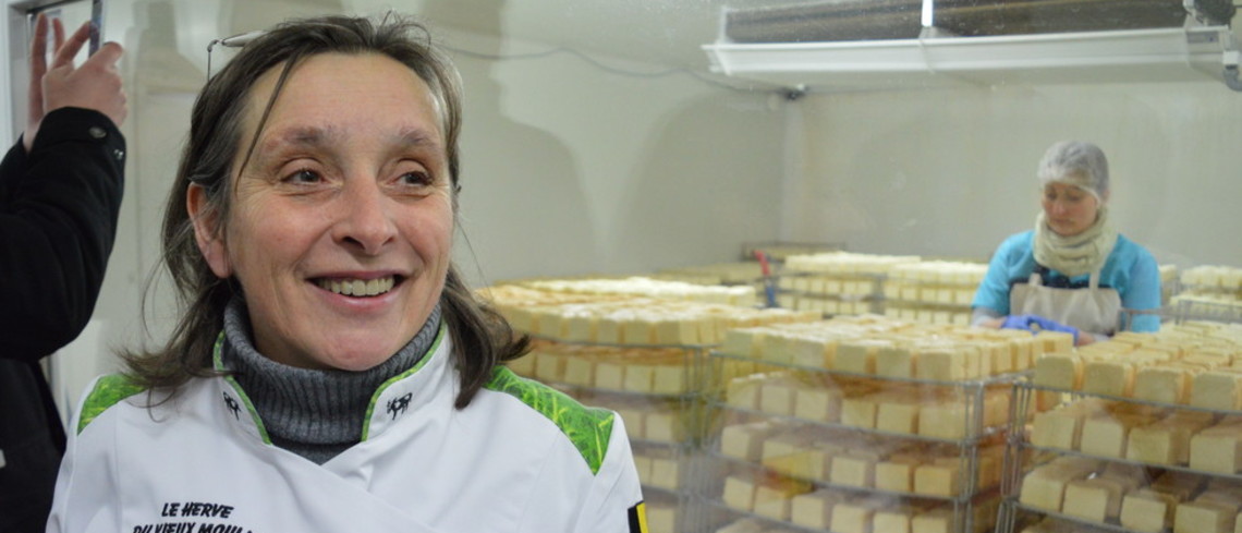 Madeleine Hanssen produit le seul fromage AOP de Belgique. Madeleine Hanssen devant une salle remplie de fromages.