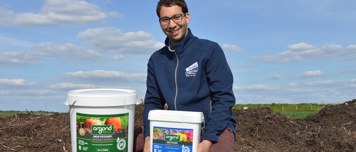 Paul Lhopiteau et son père produisent 5000 tonnes de compost par an. Portrait de Paul Lhopiteau tenant un seau de compost.