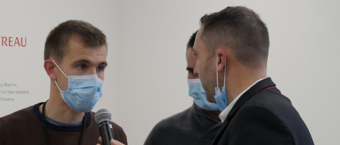 Un jeune participant en plein exercice de question-réponse avec un journaliste