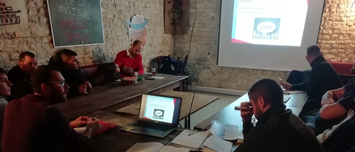 Un quinzaine de jeunes agrculteurs réunis autour d'une table pour leur assemblée générale.