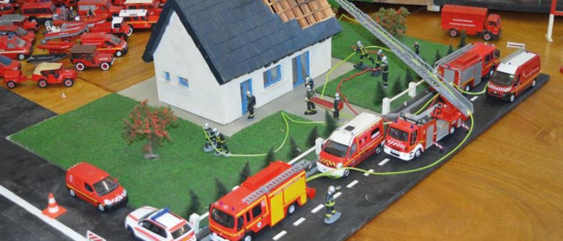 Thomas a fondé l'association Picardie Maquettes Miniatures avec des amis. Maquette d'une maison et de véhicules de pompiers tout autour.