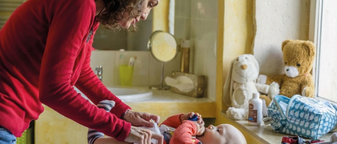 Pour l'arrivée d'un bébé, une agriculture bénéficie d'un congé de remplacement. Une femme en train de changer un bébé.