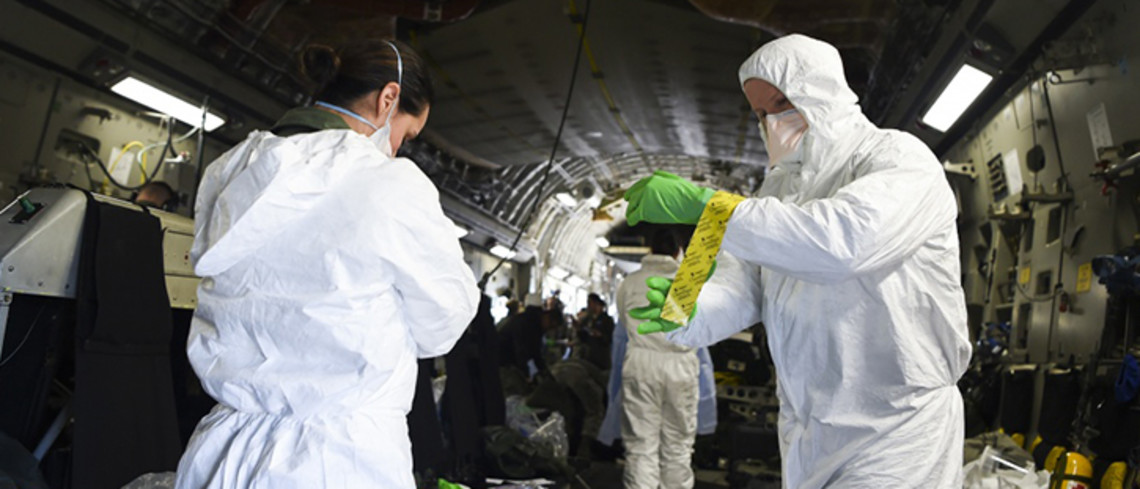 Des aviateurs enfilent un système de protection contre le covida 19. © Cody R. Miller, US Air Force Deux personnes enfilent des tenues de protection contre le coronavirus.