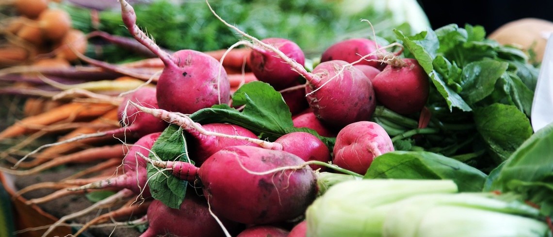 Radis et carottes sur l'étal d'un marché.