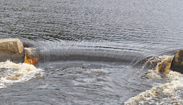 L’eau dévale un barrage dans une rivière. 