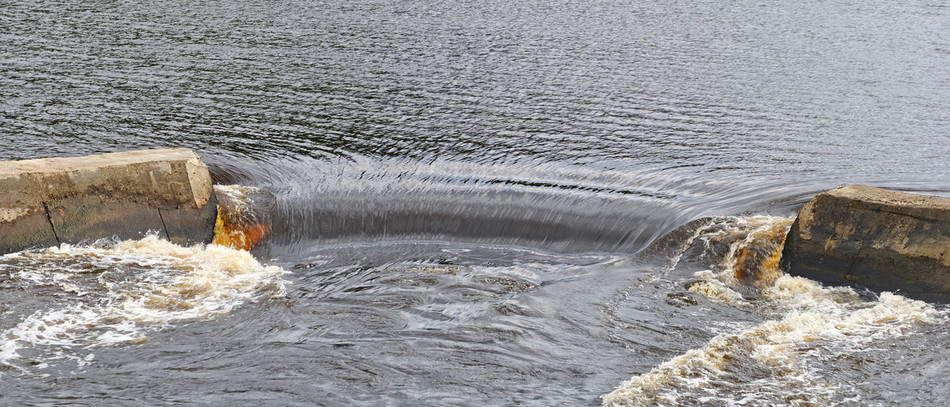 L’eau dévale un barrage dans une rivière. 