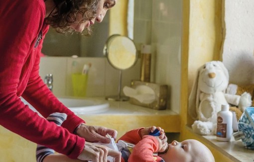 Une femme en train de changer un bébé.