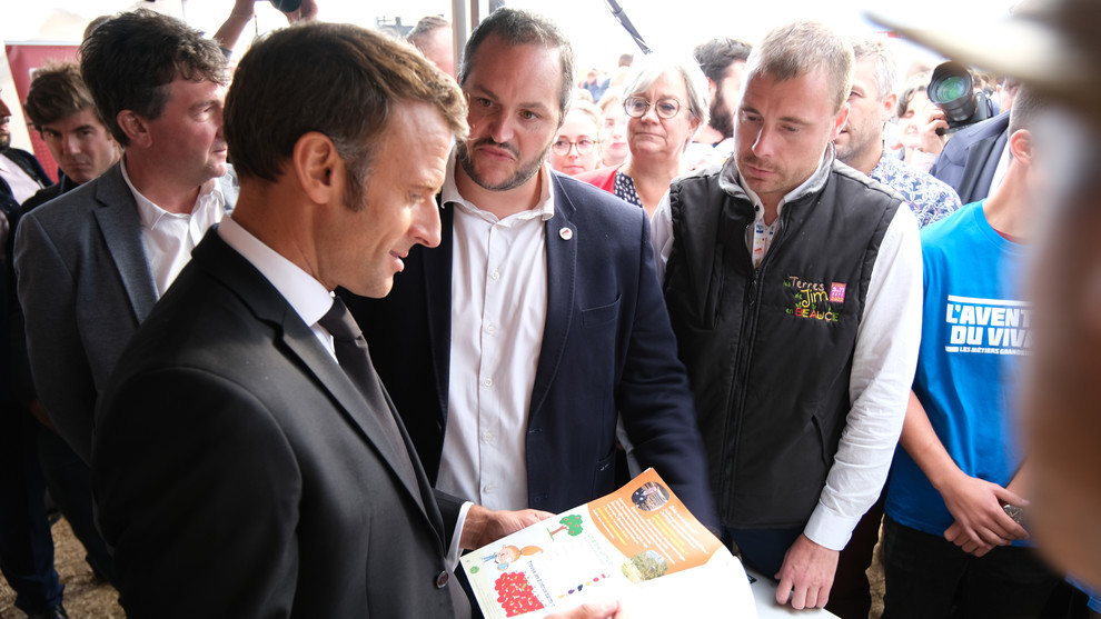 Emmanuel Macron lisant "Le p'tit agri" sur le stand des Demain je serai paysan (DJSP) Emmanuel Macron